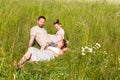 Summer sunny day for a young family, dad, mom and little girl became joyful and happy. Beautiful flower meadow, happy Royalty Free Stock Photo