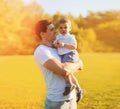 Summer sunny portrait of happy smiling young father holding little child son walking in the park together Royalty Free Stock Photo