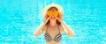 Summer sunny portrait smiling woman holds in hands oranges and hides his eyes on blue water pool background Royalty Free Stock Photo
