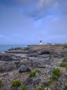 Summer sunrise with stormy clouds and slow shutter speed at Portland Bill Light, Dorset, UK Royalty Free Stock Photo