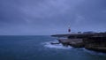 Summer sunrise with stormy clouds and slow shutter speed at Portland Bill Light, Dorset, UK