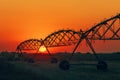 Summer sunset over agricultural field with silhouette lateral move irrigation system Royalty Free Stock Photo