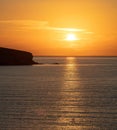 Summer sunset over Greek island, Cyclades, Greece. Golden sun colors the sky and makes sea sparkle Royalty Free Stock Photo