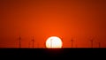 Summer sunset with red sky and windmill farm silhouette , Environmental friendly, clean energy Royalty Free Stock Photo