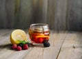 summer tea made from raspberries, blackberries, lemon and mint in a glass cup on a wooden background. ingredients nearby. proper n Royalty Free Stock Photo
