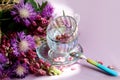 Summer tea party: cups of tea with lupine flowers, a teaspoon nearby, a bouquet of bright flowers, pastel background, space for