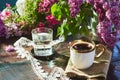 Summer terrace with cup of coffee, glass of water, summer bright flowers. Cottage core brunch with colorful summer