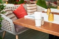 Summer terrace veranda of the cafe. Cozy gray wicker chairs with cushions, served tables and green bushes Royalty Free Stock Photo