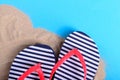 Striped slippers on sand and blue background