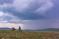 Summer thunderstorm. Mountain landscape. A stone outlier and coniferous trees against the background of mountains in the Royalty Free Stock Photo