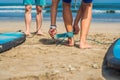 Summer time and active rest concept. Young surfer man beginner fastens leash across leg, going to surf on big barral