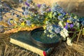 Summer time. A bouquet of flowers and dry grass. Next to the bouquet are objects that allow identifying wildflowers: a magnifying Royalty Free Stock Photo