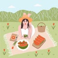 Summer time. Brunette girl in white dress and hat lies on a blanket outside the city on a picnic and eats an apple