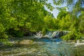 Summer time colorful landscape river stream small waterfall in forest nature environment