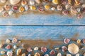 Summer time concept with sea shells on a blue wooden background and sand