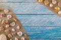 Summer time concept with sea shells on a blue wooden background and sand