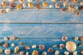 Summer time concept with sea shells on a blue wooden background