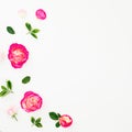 Summer time frame of pastel pink roses flowers and leaves on white background. Flat lay Royalty Free Stock Photo