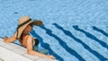 Summer time. Happy young sexy girl in bikini swimsuit, sunglasses and straw hat relaxing in blue pool water. Swimming pool water, Royalty Free Stock Photo