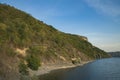 Summer time nature reservation landscape of green hill coast of lake water shoreline with blue sky background Royalty Free Stock Photo