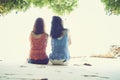 Summer time, Portrait of two young women sitting back on the beach. Royalty Free Stock Photo