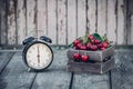 Summer Time, red cherry and an Alarm Clock on an Old Wooden Table