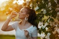 trendy 40 years old woman in white shirt using nasal spray Royalty Free Stock Photo