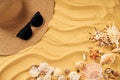 Summer time vacation concept. Straw hat, sunglasses and seashells on the sand beach with copy space for text Royalty Free Stock Photo