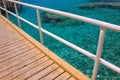 Summer time vacation season coral beach scenic view wooden bridge above Red sea background aquamarine water Royalty Free Stock Photo