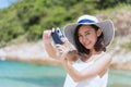 Summer time woman vacation on the beach. Cheerful woman wear summer dress and straw hats sitting on the beach look at sea. Time to Royalty Free Stock Photo