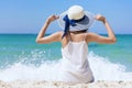 Summer time woman vacation on the beach. Cheerful woman wear summer dress and straw hats sitting on the beach look at sea. Time to Royalty Free Stock Photo