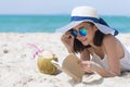 Summer time woman vacation on the beach. Cheerful woman wear summer dress and straw hats sitting on the beach look at sea. Time to Royalty Free Stock Photo