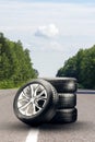 summer tires and alloy wheels set on an asphalt road. tire change season, auto trade, copy space , . auto tuning and Royalty Free Stock Photo