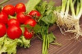 Summer tomatoes and greens on rustic wooden table Royalty Free Stock Photo