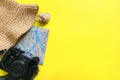 Summer travel accessories on yellow background. Flat lay beach hat, vintage camera, plane, map, passport, sunglasses, seashells Royalty Free Stock Photo