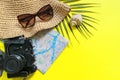 Summer travel accessories on yellow background. Flat lay beach hat, vintage camera, plane, map, passport, sunglasses, seashells Royalty Free Stock Photo
