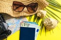 Summer travel accessories on yellow background. Flat lay beach hat, vintage camera, plane, map, passport, sunglasses, seashells Royalty Free Stock Photo