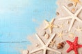 Summer travel background from seashell, starfish and sand on blue table top view.