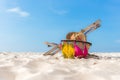 Summer Travel. Bikini and Flip-flops ,hat, fish star and bag near beach chair on sandy beach against blue sea and sky background, Royalty Free Stock Photo