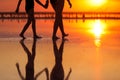 Summer travel holiday. Cropped photo of silhouette legs mom and child daughter walk together on sunset beach