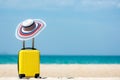 Summer travel and plan with yellow suitcase luggage in the sand beach. Travel in the holiday trips, airplane and blue sky backgrou Royalty Free Stock Photo