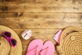 Summer travel saving budget concept with piggy bank, hat and flip flops on wooden table. Top view from above