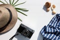 Summer travel vacation background with sun hat, camera, sea shells, tropical palm leaf on white background. Flat lay composition Royalty Free Stock Photo