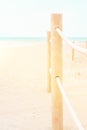 Summer travel vacation concept. White pinkish beach sand turquoise ocean blue sky. Tranquil idyllic scene. Rope railing