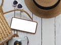 summer travel vacation flat lay concept. photo camera and hat sunscreen phone with empty screen and sunglasses on white wooden bag Royalty Free Stock Photo