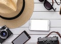 summer travel vacation flat lay concept. photo camera and hat sunscreen phone with empty screen and sunglasses on white wooden bag Royalty Free Stock Photo