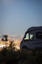 Summer travel vehicle vacation lifestyle. Modern camper van parked against a beautiful colored sunset on the ocean. Adventure Royalty Free Stock Photo