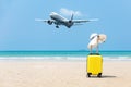 Summer traveling and planning with yellow suitcase luggage with big white hat fashion on the sand beach. Royalty Free Stock Photo