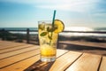 Glass of cold fresh summer cocktail on wooden table with ocean view on background Royalty Free Stock Photo