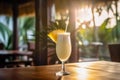 Glass of summer tropical cocktail and pineapple on wooden table in a bar with ocean view on background Royalty Free Stock Photo